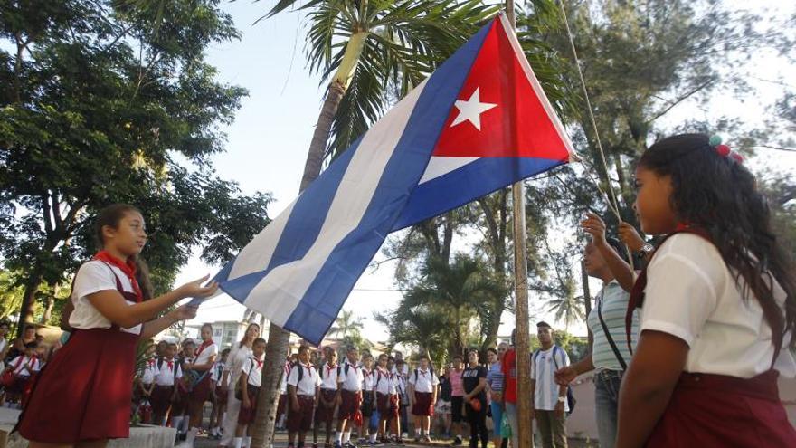 niños cubanos izando bandera